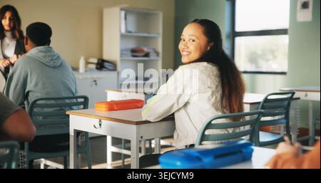 Education, girl and happy in college class for portrait, learning pride and student scholarship. Academy, confident person and lecture on campus for Stock Photo