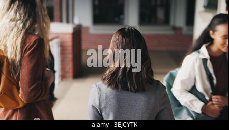 Friends, education and women at hallway in college, back and walking to class for development. University, students and people in corridor for campus Stock Photo