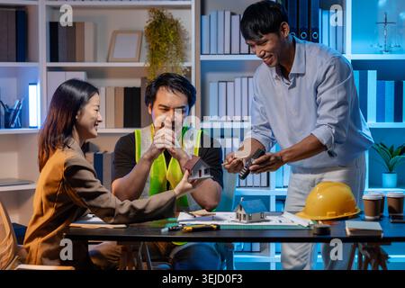 A team of architects and engineers coordinates on an architectural project, reviewing design concepts and technical plans to ensure efficiency and cre Stock Photo