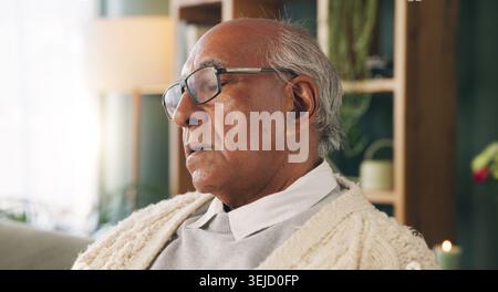 Tired, sleeping and old man in living room with rest, glasses and peaceful retirement in nursing home. Elderly person, fatigue and relax on couch Stock Photo