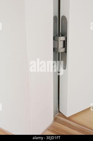 Stainless door hinges on white  swing door for interior design. Modern door hinge. Stock Photo