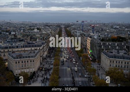 Paris, France - 8 Nov 24: High-angle evening view down the Champs-Élysées with heavy traffic, Haussmann buildings, and construction cranes in Paris, F Stock Photo