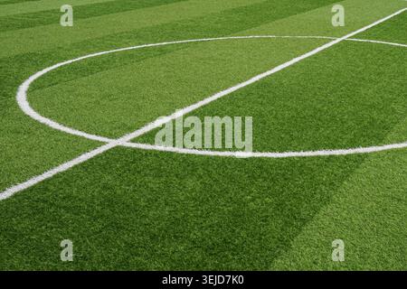 Fresh green turf glows under bright light. White lines mark perfect geometry on the field. No players, no action-calm, empty space awaits. Ideal for sports, design, or background visuals. Stock Photo