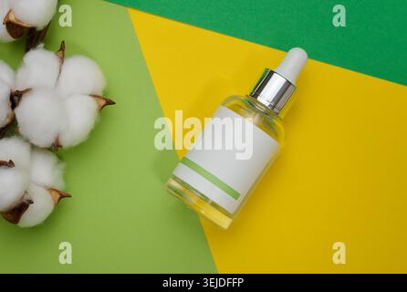 White glass bottle with a pipette and a empty white label. Container for cosmetics, serum and oil. Mockup skincare product Stock Photo