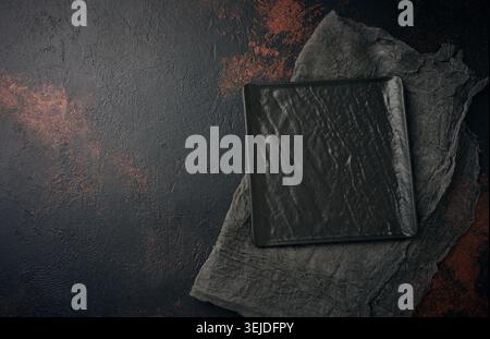 Square stone kitchen board on black background, top view Stock Photo