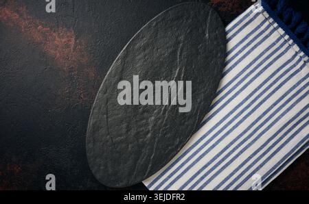 Oval stone kitchen board on black background, top view Stock Photo