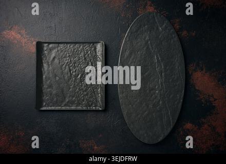 Oval and square stone kitchen board on black background, top view Stock Photo