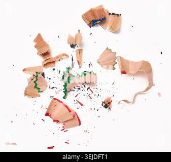 Wood shavings from multi-colored wooden pencils on white background, top view Stock Photo