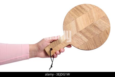 Woman's hand holding empty round wooden cutting board on isolated background Stock Photo