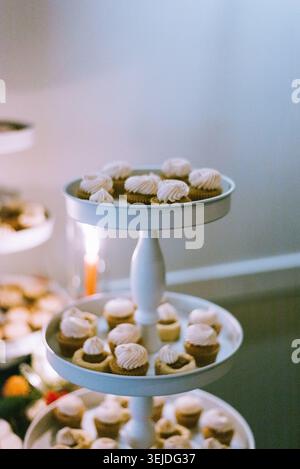 Mini cupcakes with white frosting on a tiered stand Stock Photo