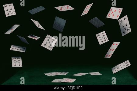Playing cards fall on a green table Stock Photo