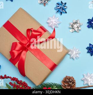 Decorative Christmas branch with red berries and pine cones on a blue background Stock Photo