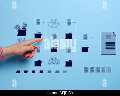 Concept of control and systematization of documents and data, female hand pointing to folder and file structure on blue backgrou Stock Photo