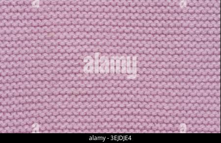 Knitted fabric made of pink wool threads, pigtail pattern, full frame. Stock Photo