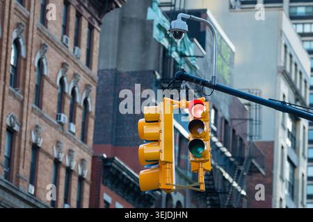 Red traffic light and security camera on city street Stock Photo