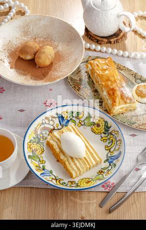 An assortment of delicious desserts and tea on a wooden table Stock Photo