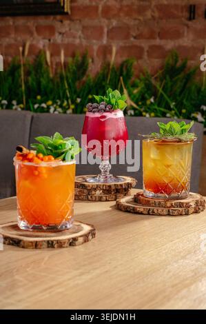 Three colorful craft cocktails on a wooden table Stock Photo