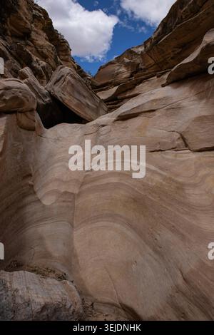 Curved Sandstone Canyon Walls Under Desert Sky Stock Photo
