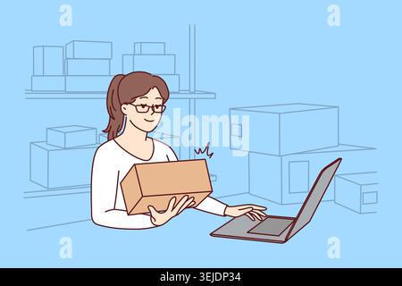 Woman working on laptop at warehouse Stock Photo