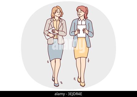 Businesswomen walk talking in office Stock Photo