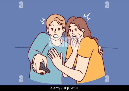 Frightened man and woman with TV remote control are shocked after watching scary movie Stock Photo