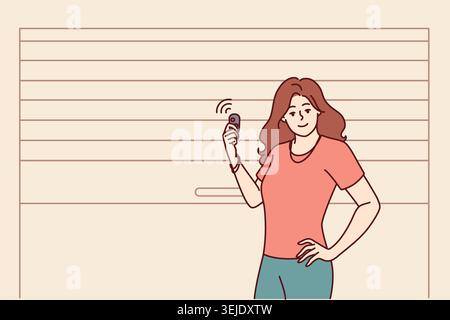 Woman stands near garage door pvc and uses electronic key to automatically open or close entrance Stock Photo