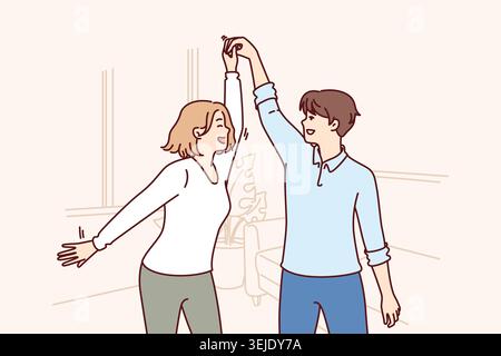 Cheerful couple dancing in apartment rejoicing moving and relocation to new house taken on mortgage Stock Photo