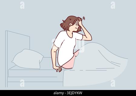 Woman woke up with nightmare and sits in bed holding head, in need of sleeping pills Stock Photo