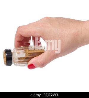 Female hand holding container with ground cinnamon on isolated background Stock Photo