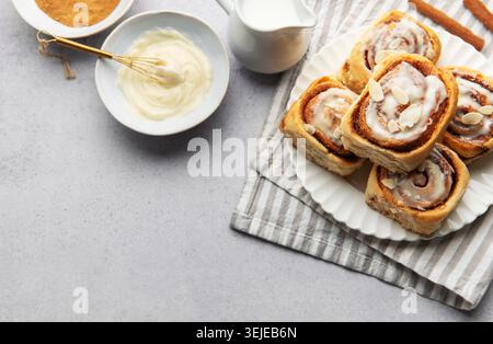 Freshly baked cinnamon rolls topped with icing and almond slivers Stock Photo