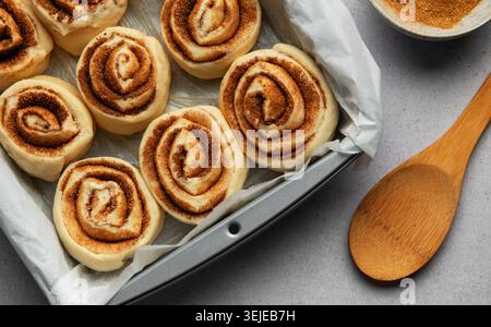 Delicious cinnamon rolls prepared for baking in a rectangular pan Stock Photo