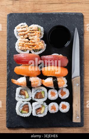 Assorted Sushi Selection and soy sauce on slate tray on wooden table Stock Photo