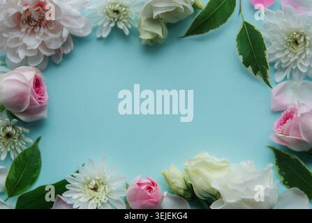 Flowers composition. Frame made of pink flowers on pastel blue background. Stock Photo