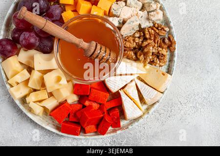Appetizer, assorted cheese, with nuts and honey, on a round plate, top view, no people, Stock Photo