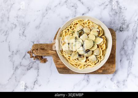 Spaghetti with vongole clams, in cream sauce, carbonara, on a marble table, homemade, top view, no people, Stock Photo