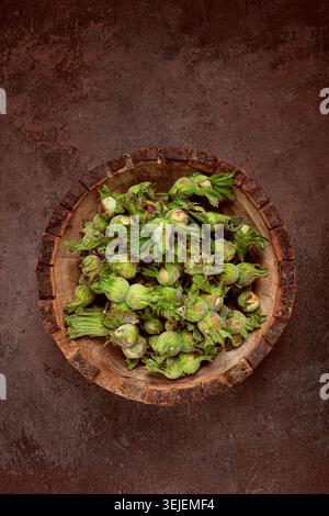 Fresh, green hazelnuts, close-up, in a wooden bowl, unpeeled, top view, no people, Stock Photo