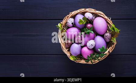 Easter eggs, purple and lilac , on a gray wooden table, Easter card, banner, selective focus, horizontal Stock Photo