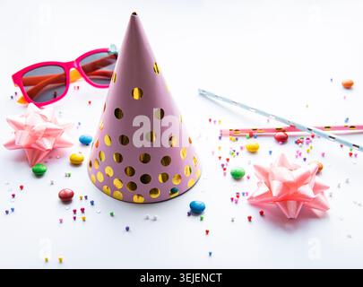 Birthday party caps, decorations and confetti on a white background Stock Photo