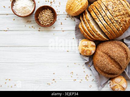 Assortment of baked bread on white wooden background Stock Photo
