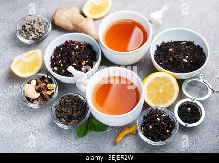 Cups of tea with aromatic dry tea in bowls Stock Photo