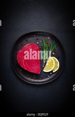Fresh red tuna fillet, for steak, raw, top view, on a black plate , no people, Stock Photo