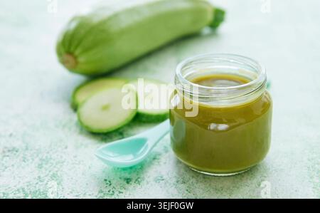 Jar with healthy baby food and zucchini Stock Photo