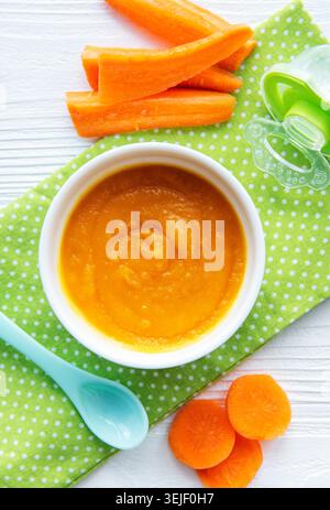 Baby carrot mashed with spoon in bowl Stock Photo