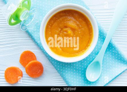 Baby carrot mashed with spoon in bowl Stock Photo