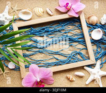 Blue Fishing net  and wooden frame on a beach sand, travel concept Stock Photo
