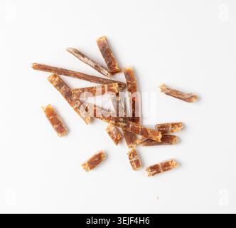 Fish Jerky Isolated, Dry Salted Seafood Snack, Hake Stockfish, Small Pieces of Dehydrated Pollock, Beer Snacks, Dried Fish Fillet on White Background Stock Photo