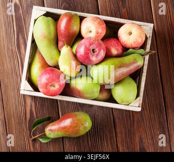 Pears and apples in wooden box on table Stock Photo