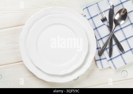 Empty plate and silverware over wooden table Stock Photo