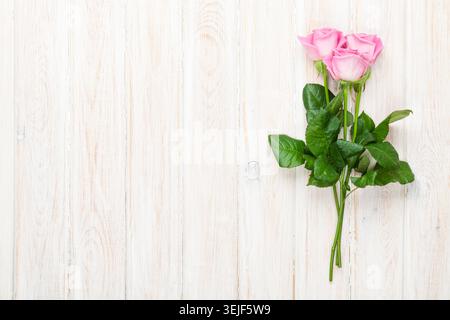 Pink roses bouquet over white wooden table Stock Photo