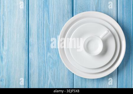 Empty plates and bowls on blue wooden background Stock Photo
